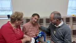 Eva and Erik welcome our pastor while sitting on the couch in the House of Smiles.